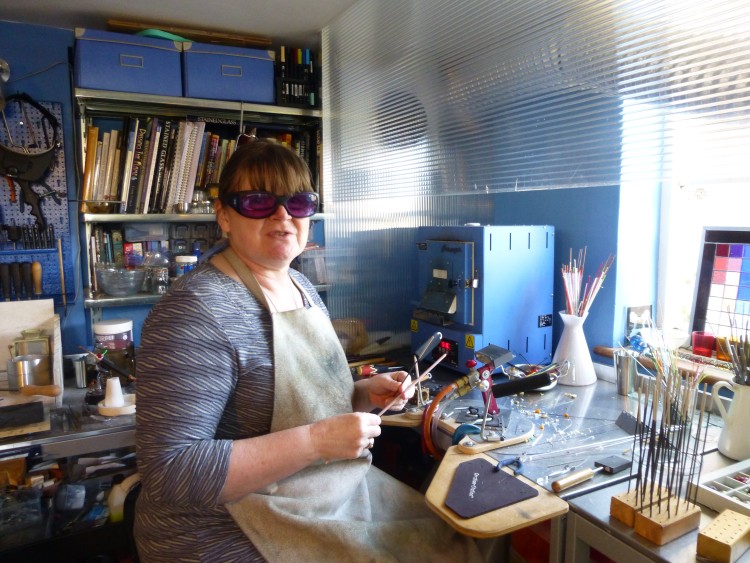 Cathy Allen in her studio, wearing protective glasses and apron